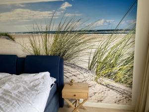 a bedroom with a bed and a view of the beach at Place 2 Beach Next to Ijsselmeer in Lemmer