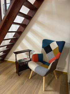 a chair and a table in a room with a staircase at Atypique et central : 4 personnes + Parking privé in Bourges