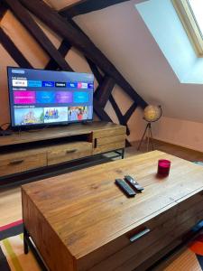 - un salon avec une télévision et une table basse en bois dans l'établissement Atypique et central, 4 personnes et garage privé, à Bourges