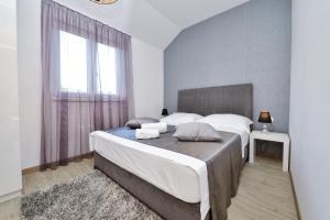 a bedroom with a large bed and a window at Premium Villa Zečevo in Rogoznica