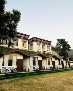 eine Reihe von Häusern mit Bäumen darüber in der Unterkunft The Bluewind Resort in Dehradun
