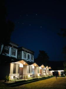 a man standing in front of a house at night at The Bluewind Resort in Dehradun