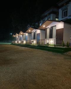 Una fila de casas iluminadas por la noche en The Bluewind Resort en Dehradun