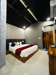 The Bluewind Resort في دهرادون: غرفة نوم بسرير كبير في غرفة