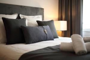 - une chambre avec un grand lit blanc et des oreillers dans l'établissement Fivos Luxury Suite, à Athènes