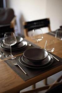 a table with two plates and wine glasses on it at Fivos Luxury Suite in Athens