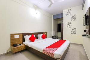 a bedroom with a large bed with red pillows at Collection O Shree Dhoramnath in Nakhtarāna