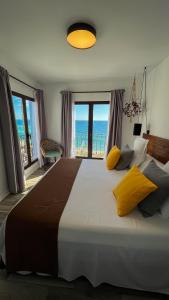 a bedroom with a large bed with a view of the ocean at Hostal Boutique Casa del Mar Altea in Altea