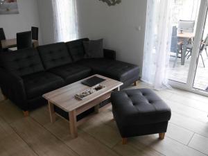 a living room with a black couch and a coffee table at FH Moewenkoje in Ostseebad Karlshagen +17 photos