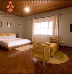 阿魯沙的住宿－Asante Home，一间卧室配有床、椅子和窗户
