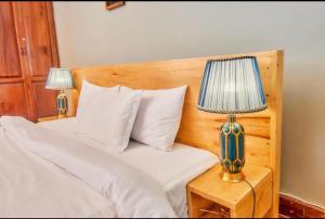 sypialnia z łóżkiem z 2 lampkami na szafce nocnej w obiekcie Asante Home w mieście Arusza
