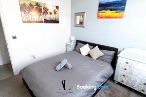 a bedroom with a bed and a dresser at The Den 2 Bedroom Serviced Apartment By AltoLuxoExperience Short Lets & Serviced Accommodation With Free Wifi in Bristol