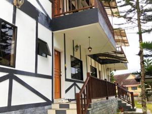 a house with a staircase leading to the front door at PLAY at Arabella Tudor House in Tanah Rata