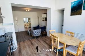 a kitchen and living room with a table and chairs at The Den 2 Bedroom Serviced Apartment By AltoLuxoExperience Short Lets & Serviced Accommodation With Free Wifi in Bristol