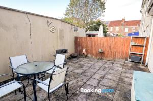 a patio with a table and chairs and a fence at The Den 2 Bedroom Serviced Apartment By AltoLuxoExperience Short Lets & Serviced Accommodation With Free Wifi in Bristol