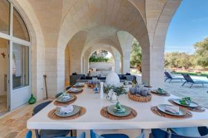 a large white table in a room with an archway at Tenuta Palù By Raro Villas in Carovigno