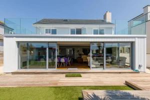 a house with large glass doors and a patio at The Kite House in East Wittering
