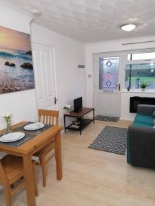 a living room with a table and a couch at Entire Cosy bungalow close to Beach in Heacham