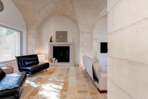a living room with a couch and a fireplace at Tenuta Palù By Raro Villas in Carovigno