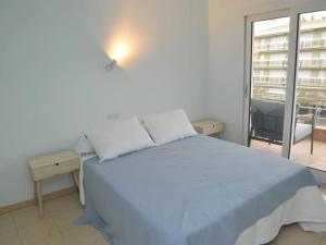 ein Schlafzimmer mit einem blauen Bett und einem Fenster in der Unterkunft Apto a 1 minuto de la Playa en Sant Antoni in Sant Antoni de Calonge