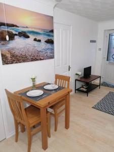 a dining room with a wooden table and chairs at Entire Cosy bungalow close to Beach in Heacham