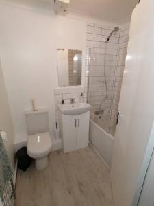 a bathroom with a toilet and a sink and a shower at Entire Cosy bungalow close to Beach in Heacham