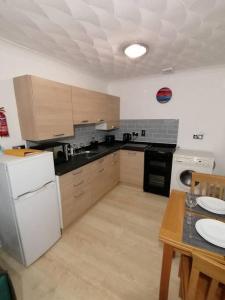 a kitchen with a white refrigerator and a table at Entire Cosy bungalow close to Beach in Heacham