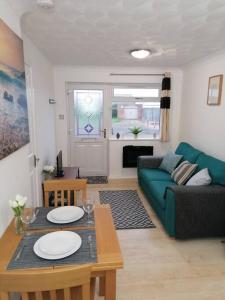 a living room with a green couch and a table at Entire Cosy bungalow close to Beach in Heacham +5 photos