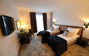 ルブリンにあるHotel Focus Centrum Konferencyjneのベッド2台とテレビが備わるホテルルームです。