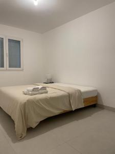 1 dormitorio blanco con 1 cama con 2 toallas en Villa Lancrans en Lancrans