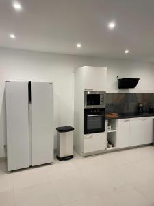 uma cozinha com armários brancos, um fogão e um frigorífico em Villa Lancrans em Lancrans