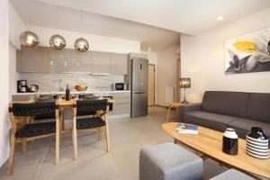雅典的住宿－Fivos Luxury Suite，厨房以及带沙发和桌子的客厅。