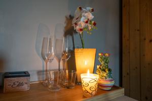 a table with wine glasses and a vase with flowers at Agàpe Rooms in Tropea in Tropea