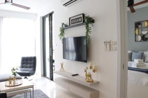 a living room with a tv on a wall at Cassia Residences by NLA in Bang Tao Beach