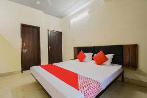 a bedroom with a large bed with red pillows at Super OYO Olive Grand in Patna