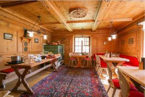 Habitación grande con paredes de madera, mesas y sillas. en Gasthaus & Hotel Berninahaus, en Pontresina