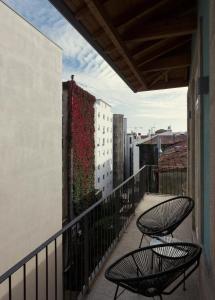 Laranjais Boutique Suites & Apartments Porto في بورتو: وجود كرسيين للجلوس على شرفة المبنى