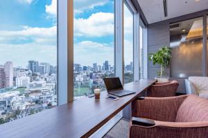 ein Büro mit einem Schreibtisch, einem Laptop und Stühlen in der Unterkunft Tokyu Stay Aoyama Premier in Tokio