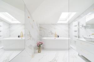 a white bathroom with two sinks and two mirrors at White Lotus - LoftAffair Collection in Kraków
