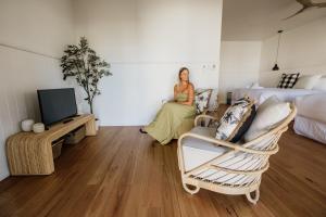 una mujer está sentada en una sala de estar en Sur Mer Studio - Seaside Escape en Dunsborough