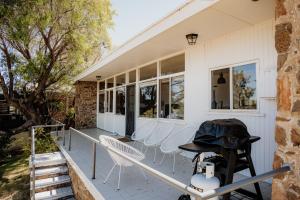 a porch with white chairs and a table at Sur Mer Studio - Seaside Escape in Dunsborough