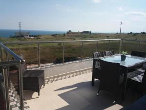 a balcony with a table and chairs and the ocean at Villa Bellerose in Bozhurets