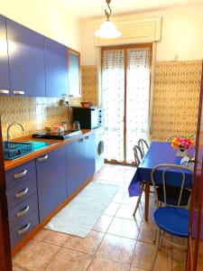 een keuken met blauwe kasten en een tafel met een eetkamer bij PERLA MARINA in Gallipoli