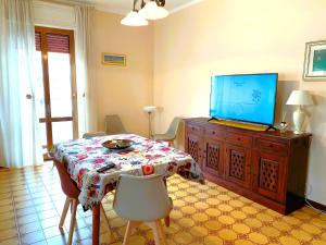 een woonkamer met een tafel en een tv op een kast bij PERLA MARINA in Gallipoli