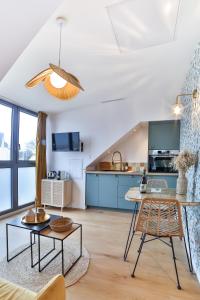 een keuken en een woonkamer met een tafel en stoelen bij Les Voiles - Appart'hotel "Le Nordet" in Carnac