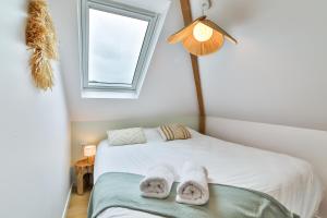 een slaapkamer met een bed met handdoeken erop bij Les Voiles - Appart'hotel "Le Nordet" in Carnac