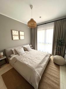 um quarto com uma cama grande e uma janela grande em SmartApt Elegant 1 BDR Burj view em Dubai