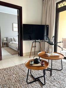 uma sala de estar com duas mesas e um quarto em SmartApt Elegant 1 BDR Burj view em Dubai