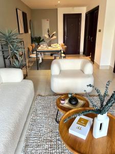 a living room with a white couch and a table at SmartApt Elegant 1 BDR Burj view in Dubai