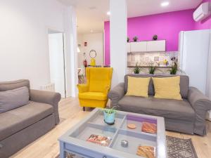 a living room with two couches and a yellow chair at Enorme y acogedor piso en la puerta del sol in Madrid